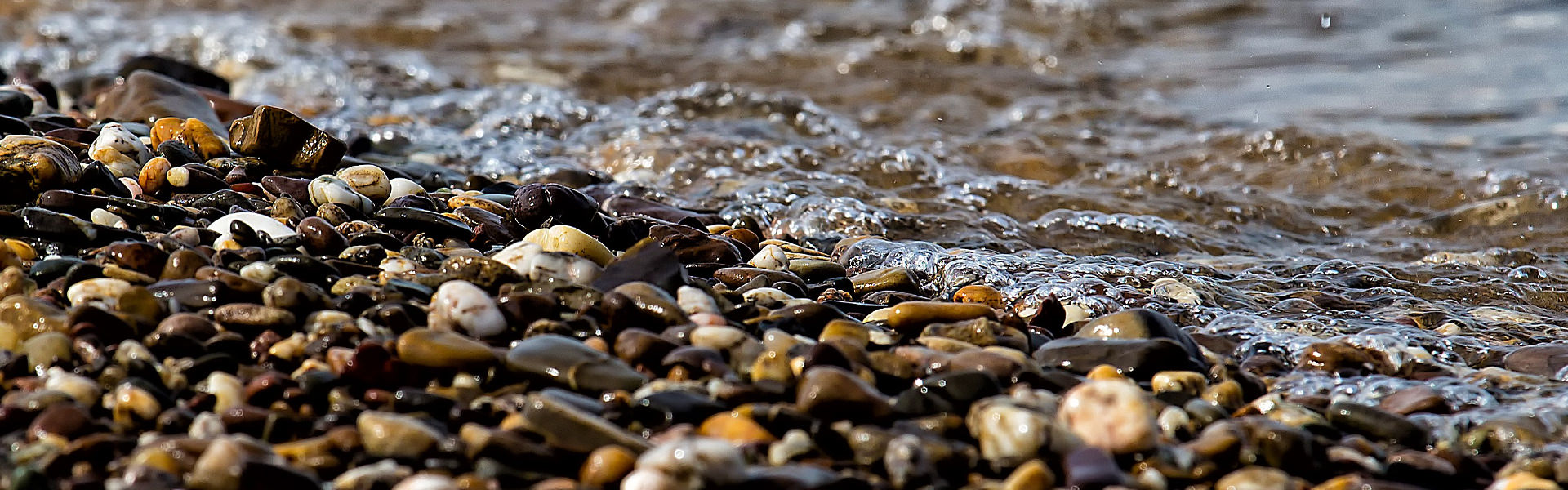 Stones near a beach with water lapping on the shore